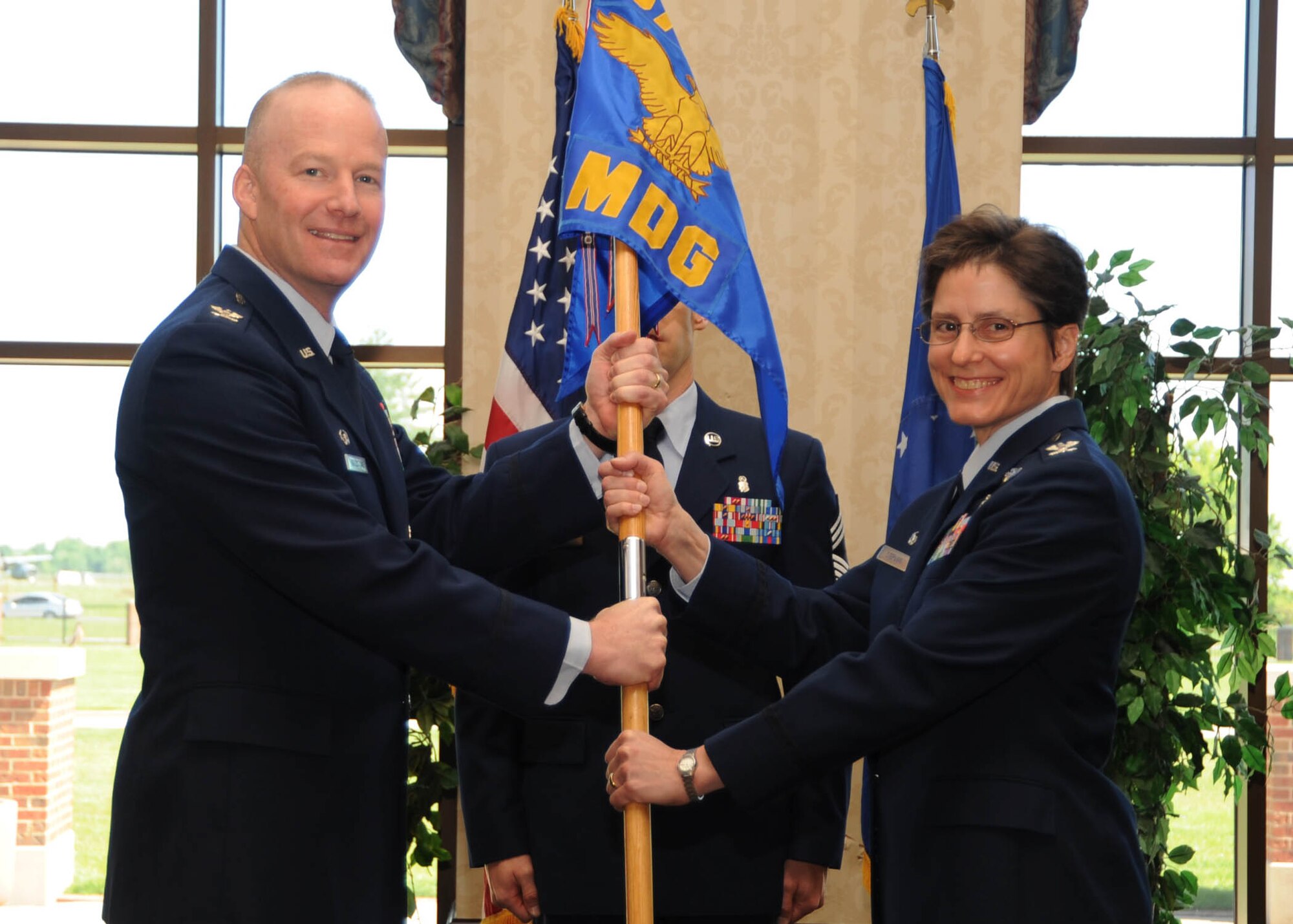 SCOTT AIR FORCE BASE, Ill. -- Col. Gary Goldstone, 375th Airlift Wing commander, passes the 375th Medical Group guidon to the new commander, Col. Jill Sterling, during the 375th MDG’s change of command ceremony Monday at the Scott Club. Colonel Sterling assumed command from Col. Dianne Ritter. (U.S. Air Force photo/Airman 1st Class Wesley Farnsworth)