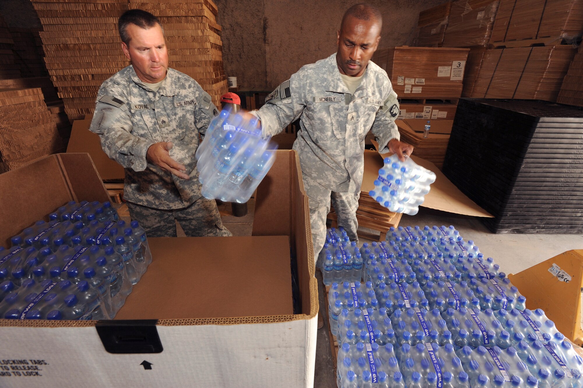 U.S. Army Sergeant's Karol Koval and Robert McNeely, both riggers with the 824th Quarter Master Company, load drinking water into an airdrop delivery container, June 3, 2009, in an undisclosed location in Southwest Asia.  Riggers provide vital supplies to servicemembers throughout the U.S. Central Command's area of responsibility by preparing these supply pallets for air-drop delivery by C-17 Globemaster III aircraft.  Sergeant Koval is native to Fayetteville, N.C. and Sergeant McNeely hails from Mooresville N.C., both are deployed in support of Operations Iraqi and Enduring Freedom and Combined Joint Task Force - Horn of Africa.  (U.S. Air Force Photo by Staff Sgt. Joshua Garcia/released)