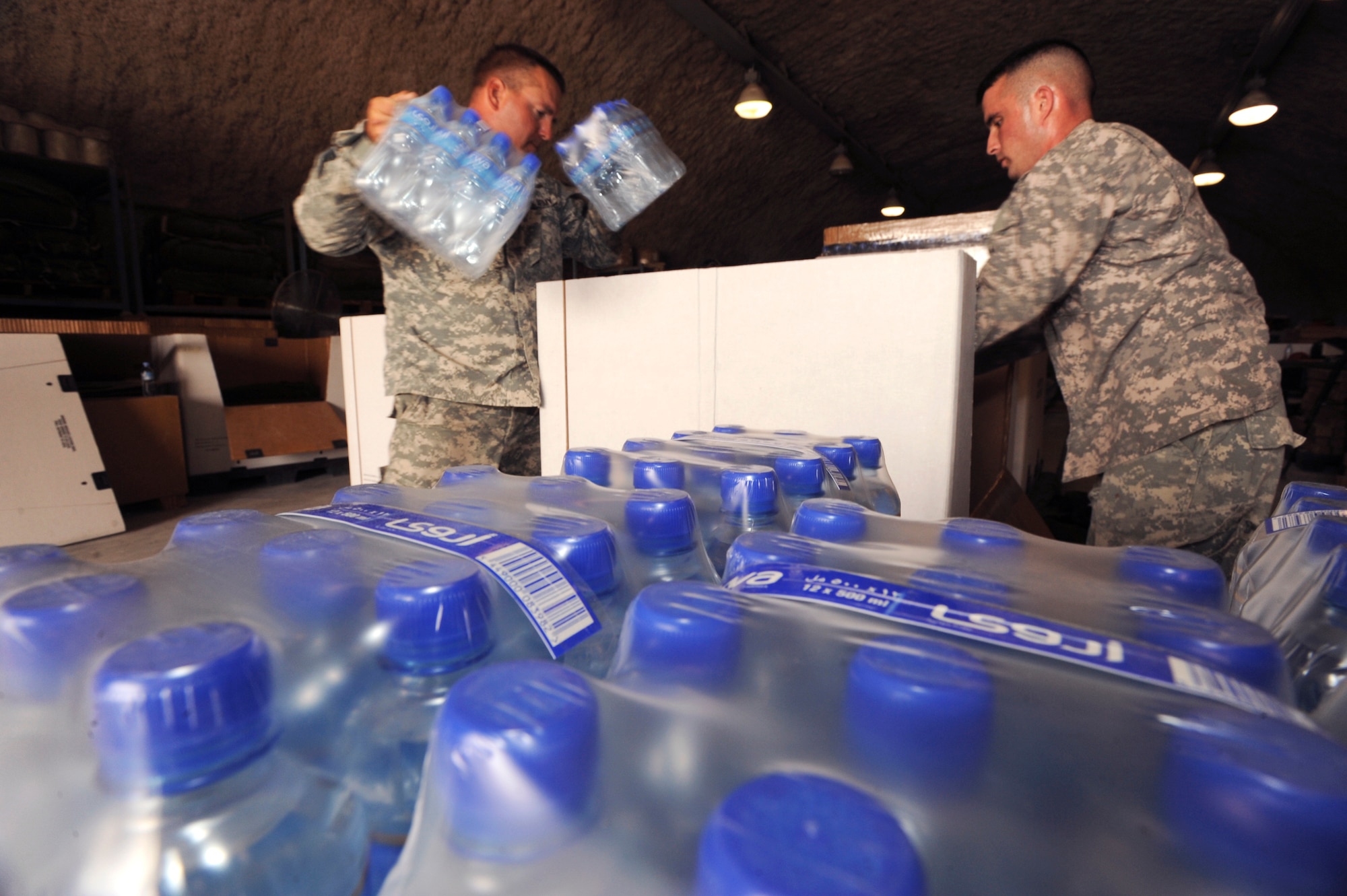 U.S. Army Sergeant's Karol Koval and Robert McNeely, both riggers with the 824th Quarter Master Company, load drinking water into an airdrop delivery container, June 3, 2009, in an undisclosed location in Southwest Asia.  Riggers provide vital supplies to servicemembers throughout the U.S. Central Command's area of responsibility by preparing these supply pallets for air-drop delivery by C-17 Globemaster III aircraft.  Sergeant Koval is native to Fayetteville, N.C. and Sergeant McNeely hails from Mooresville N.C., both are deployed in support of Operations Iraqi and Enduring Freedom and Combined Joint Task Force - Horn of Africa.  (U.S. Air Force Photo by Staff Sgt. Joshua Garcia/released)
