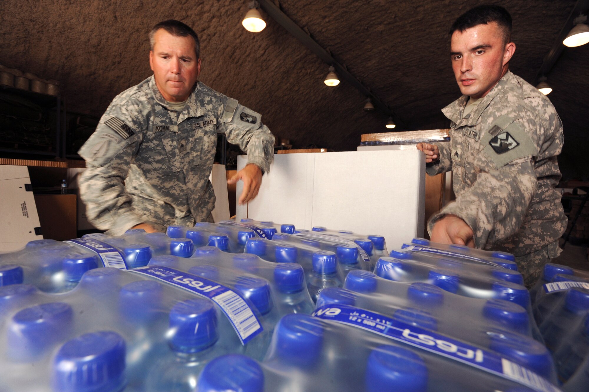 U.S. Army Sergeant's Karol Koval and Robert McNeely, both riggers with the 824th Quarter Master Company, load drinking water into an airdrop delivery container, June 3, 2009, in an undisclosed location in Southwest Asia.  Riggers provide vital supplies to servicemembers throughout the U.S. Central Command's area of responsibility by preparing these supply pallets for air-drop delivery by C-17 Globemaster III aircraft.  Sergeant Koval is native to Fayetteville, N.C. and Sergeant McNeely hails from Mooresville N.C., both are deployed in support of Operations Iraqi and Enduring Freedom and Combined Joint Task Force - Horn of Africa.  (U.S. Air Force Photo by Staff Sgt. Joshua Garcia/released)