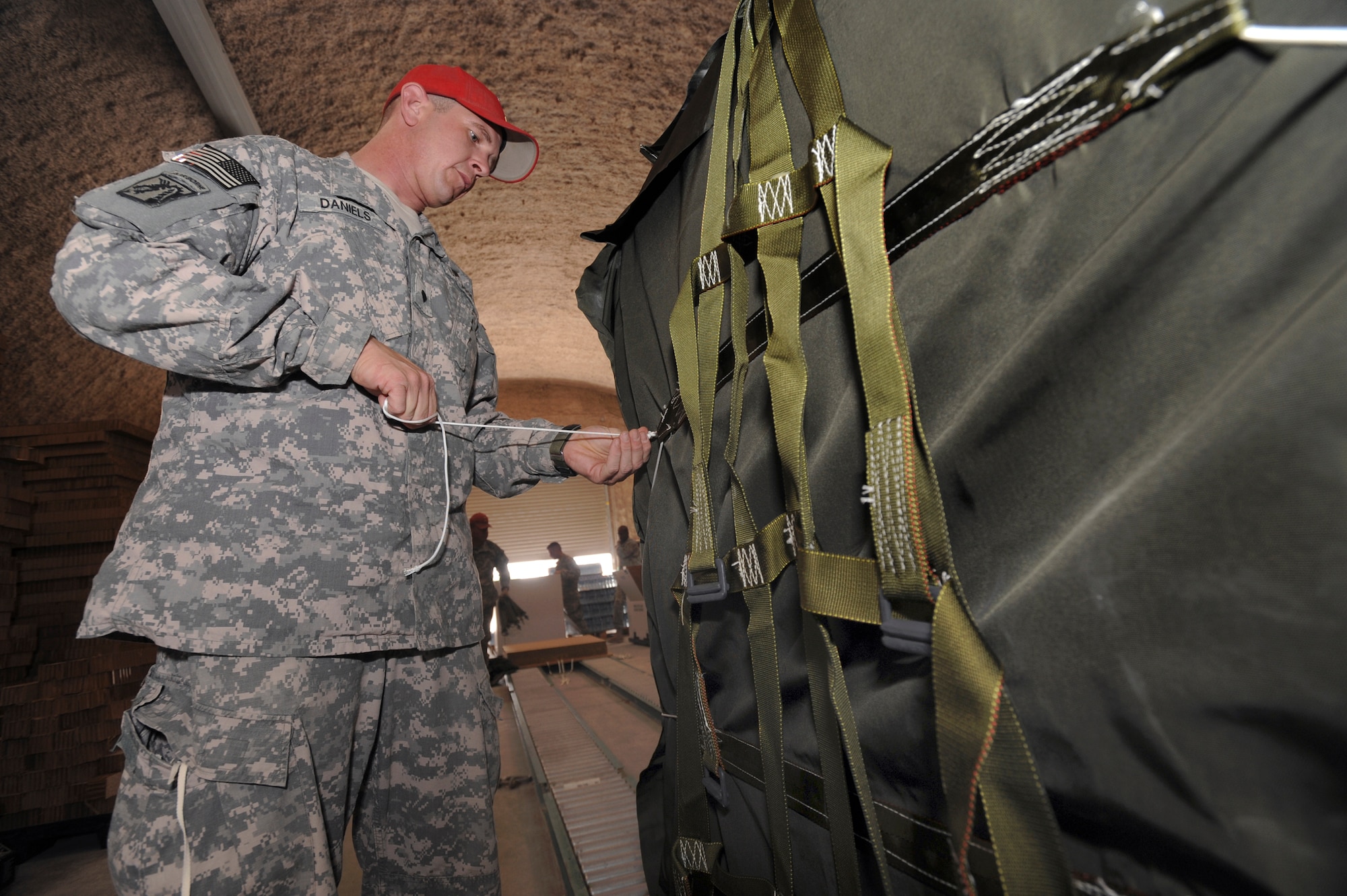 U.S. Army Specialist Josh Daniels, a rigger with the 824th Quarter Master Company, performs a final inspection on an A22-Container Delivery System, June 3, 2009, in an undisclosed location in Southwest Asia.  Riggers provide vital supplies to servicemembers throughout the U.S. Central Command's area of responsibility by preparing these supply pallets for air-drop delivery by C-17 Globemaster III aircraft.   Specialist Daniels is native to Goldsborough N.C. and is deployed from Fort Bragg N.C. in support of Operations Iraqi and Enduring Freedom and Combined Joint Task Force - Horn of Africa.  (U.S. Air Force Photo by Staff Sgt. Joshua Garcia/released)