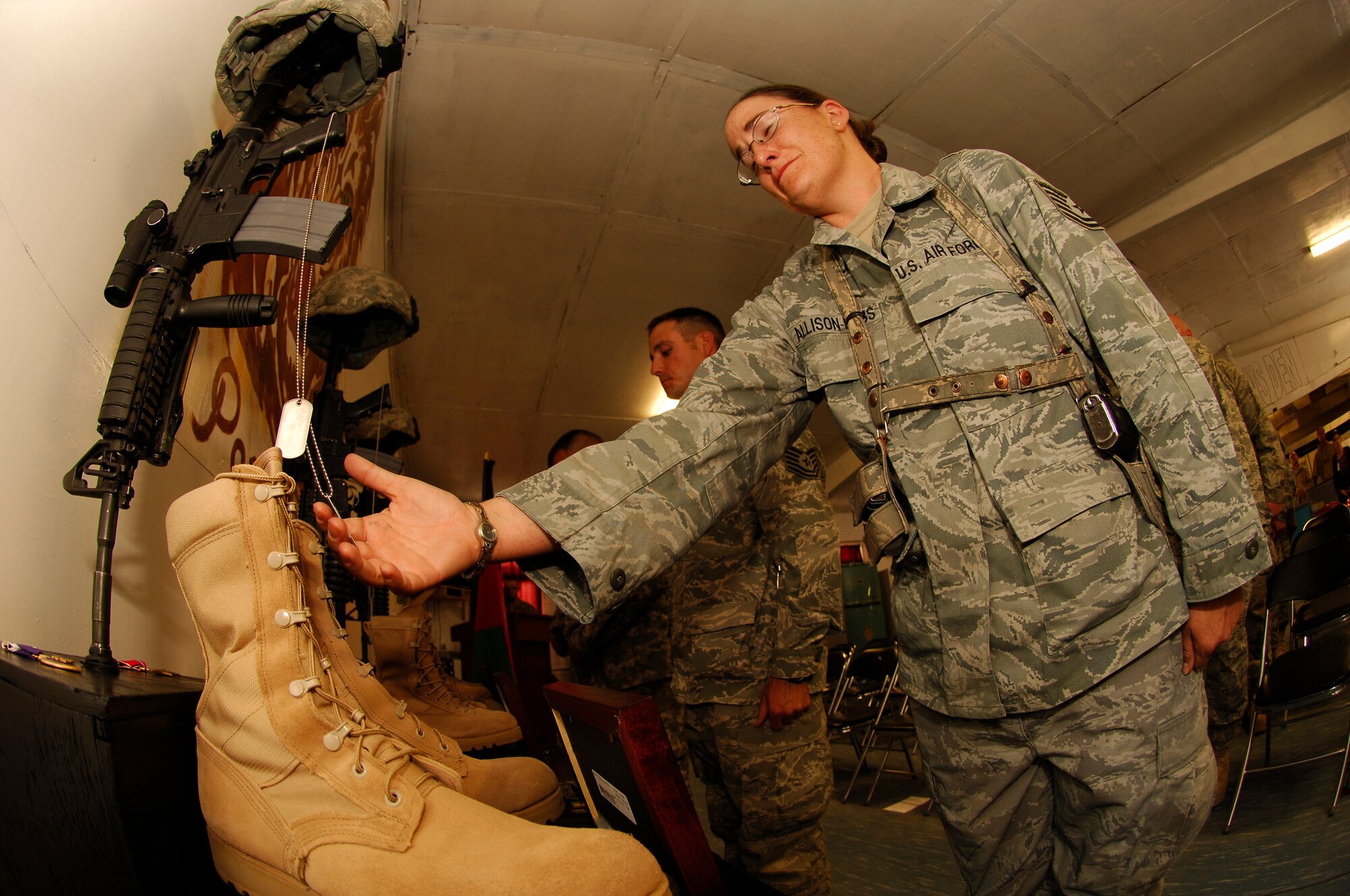 BAGRAM AIR FIELD, Afghanistan -- Tech. Sgt. Dawn Allison-Hess grieves for four of her fellow coworkers during a memorial ceremony at Forward Operating Base Lion, Panjshir Province, May 31. Air Force Lt. Col. Mark Stratton, the provincial reconstruction team's commander, Army Master Sgt. Blue Rowe, civil affairs NCO, Air Force Senior Airman Ashton Goodman, vehicle operator, and Abdul Samad, the unit's legal advisor, were killed when their convoy vehicle was struck by a suicide car bomber May 26. (Air Force/Staff Sgt. Jason Lake