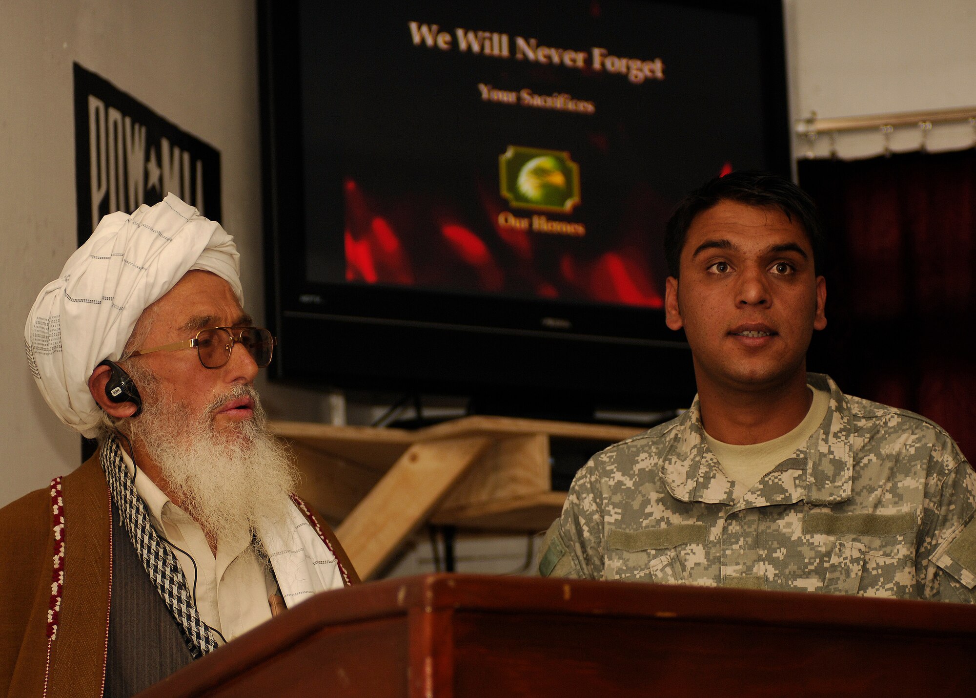 BAGRAM AIR FIELD, Afghanistan -- A Panjshir mullah, assisted by Qader, a PRT interpreter, offers a prayer and expresses his condolences for the loss of four members of the Panjshir Provincial Reconstruction Team during a memorial at Forward Operating Base Lion May 31. The mullah also shared his heartfelt appreciation for the sacrifices the team has made to improve the lives of Afghans living in Panjshir Province. (Air Force/Staff Sgt. Jason Lake)