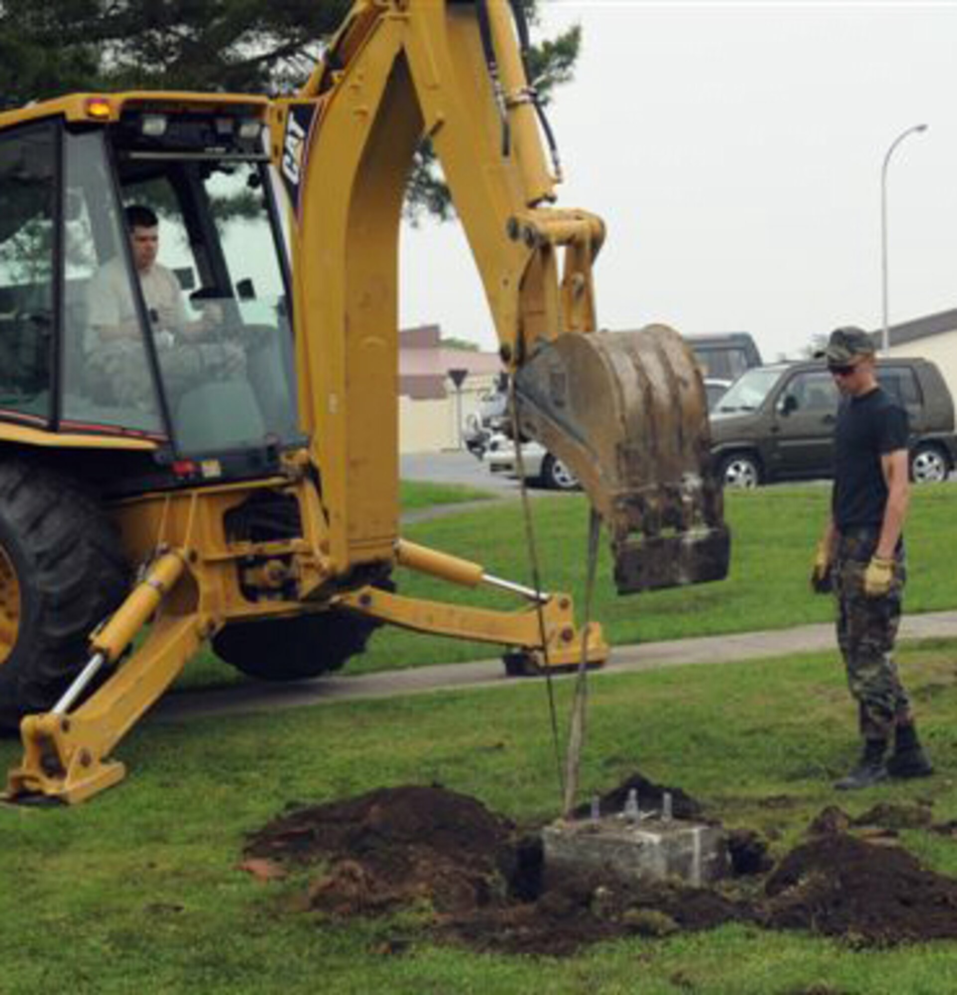 MISAWA AIR BASE, Japan -- Senior Airman Lennon Brixey and Airman 1st Class Joseph Jones, 35th Civil Engineer Squadron heavy equipment shop, remove an old light pole foundation Thursday in front of Building 668. The heavy equipment shop was called to remove a light post foundation, which was posing a tripping hazard. (U.S. Air Force photo by Staff Sgt. Phillip Butterfield)