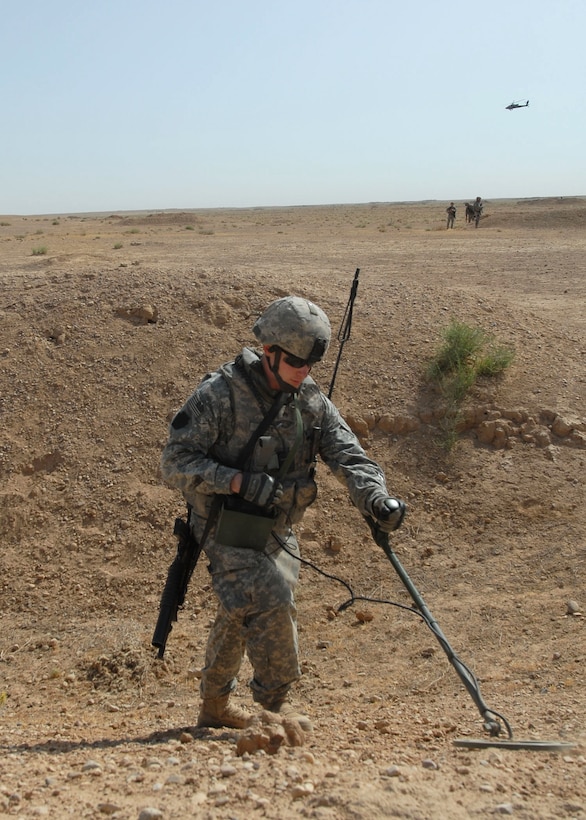 U.S. Army Sgt. Brian Reger runs a metal detector over a suspected weapons cache site in Nubai, Iraq, June 3, 2009. Reger is assigned to the 856th Engineer Company, 56th Stryker Brigade Combat Team. U.S. and Iraqi army soldiers worked together to search an area northwest of Taji previously used for hiding weapons.