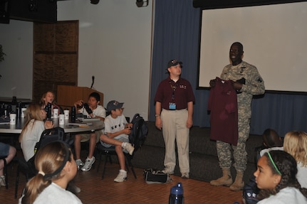 OFFUTT AIR FORCE BASE, Neb - Major General Abraham J. Turner, Chief of Staff, United States Strategic Command, talks with children at the Offutt Community Center who are participating in the Drug Education For Youth program.  More than 25 children ages 9-12 are participating in the eight day phase one event of the two phase program.  Phase two DEFY events will include monthly activities and mentoring throughout the school year.  The DEFY program at Offutt is staffed by volunteers from the United States Strategic Command, Strategic Communications Wing One Detachment Offutt (Navy), Defense Intelligence Agency and the 55th Force Support Squadron (Air Force).  DEFY originated in 1993 as a drug demand reduction program geared towards substance abuse awareness and life skills for Navy and Marine Corps dependent youths aged 9-12.  The program has expanded to 56 Navy and Marine Corps sites world-wide, and is partnered with the Department of Air Force which also has sites world-wide  and the Department of Justice, which has sites in the United States.