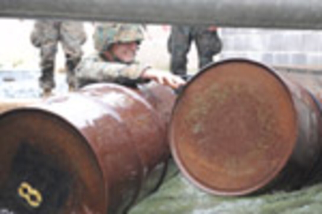Candidates from Golf Company, Officer Candidate School, conduct the Leadership Reaction Course aboard Marine Corps Base Quantico, Va., June 4, 2009. The LRC is designed to test a candidate's quick thinking and problem solving skills and encourage team work among the candidates. (U.S. Marine Corps photo by LCpl John Kennicutt/Not Released)