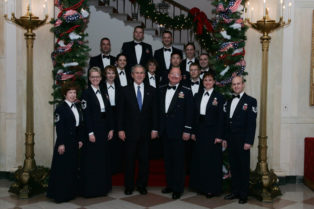 President George W. Bush takes a minute for a photo on the White House grand staircase with Colonel Layendecker and the Singing Sergeants following a performance for the President and his guests. (Official White House Photo)
