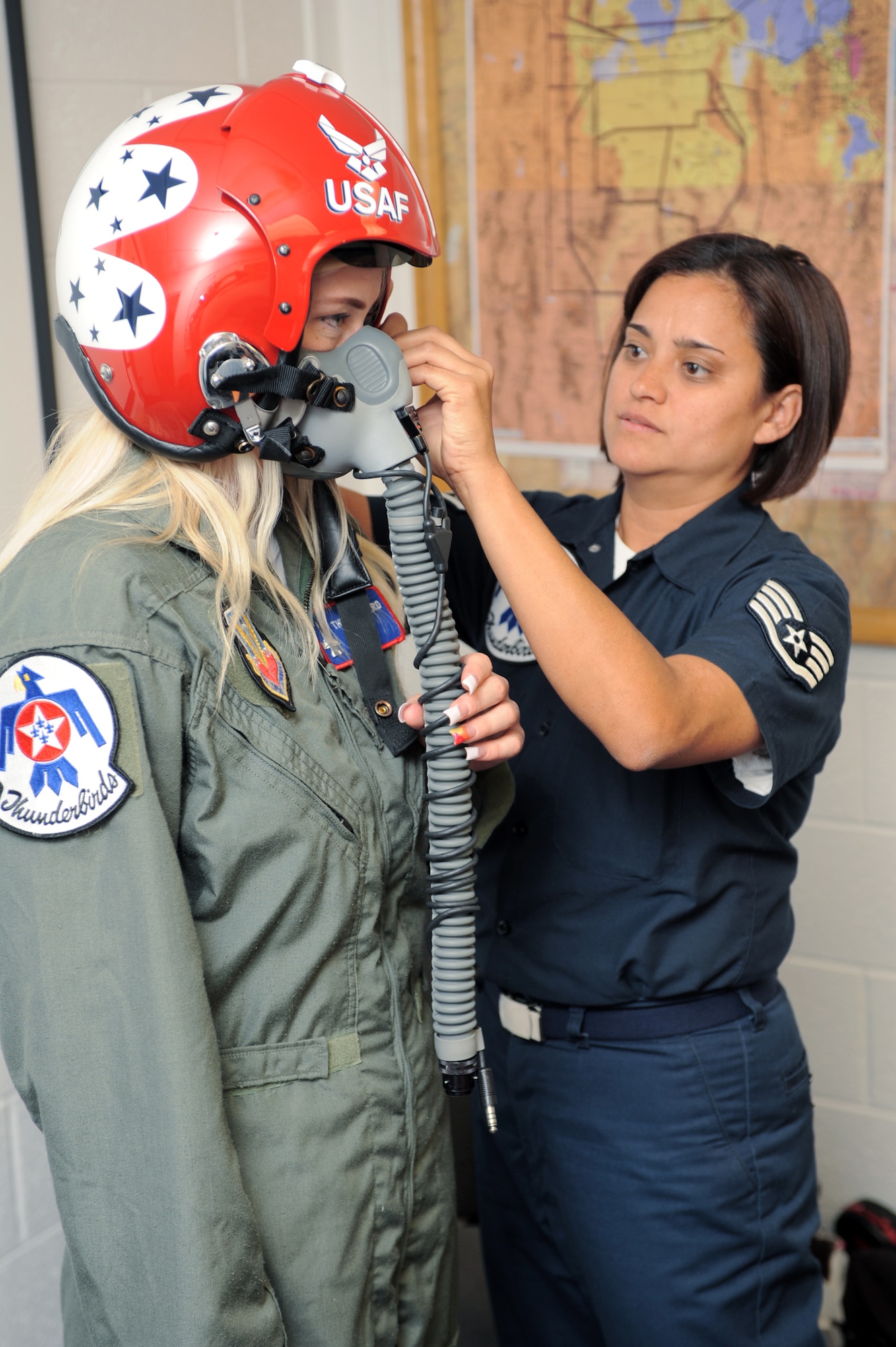 Staff Sgt. Robbin Bailon, an Air Force Thunderbirds flight equipment technician, adjusts the helmet and face mask on Megan Funk during her flight suit fitting June 4 at Hill Air Force Base, Utah.  Mrs. Funk, a second grade teacher at Majestic Elementary School in Ogden, Utah, was selected as a Hometown Hero for her volunteer service to the community for which she received a flight in a Thunderbird F-16 Fighting Falcon. (U.S Air Force photo/Tech. Sgt. Russ Martin)