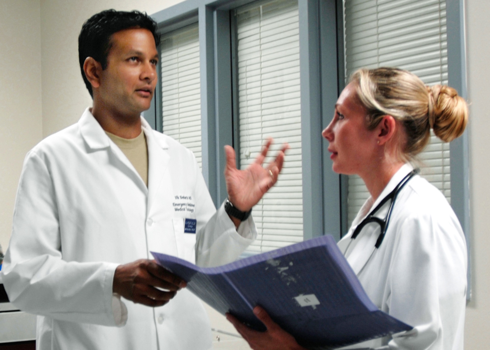Emergency physicians Majs. (Drs.) Vikhyat Bebarta (left) and Annette Williams discuss patient care in the Wilford Hall Medical Center emergency department at Lackland Air Force Base, Texas. Dr. Bebarta received the Best Basic Science Research Award from the Society of Academic Emergency Medicine for his research on treatments for cyanide poisoning.  (U.S. Air Force photo/Master Sgt. Kimberly A. Yearyean-Siers)
