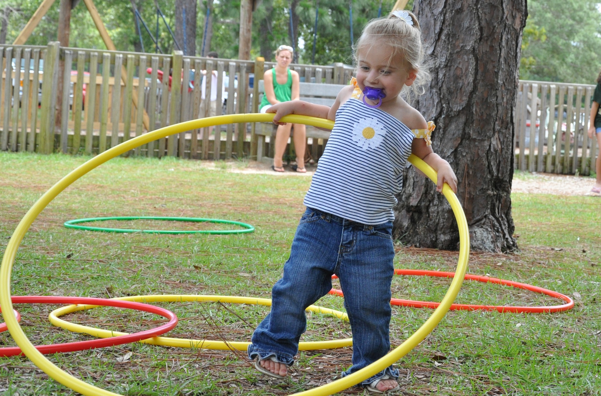 EGLIN AIR FORCE BASE, Fla. -- Madison Cain, 21-month old daughter of Seaman Brian Cain, Navy Explosive Ordinance Disposal, tries to hula hoop at the base community picnic June 5. (U.S. Air Force photo/ Airman Anthony Jennings)