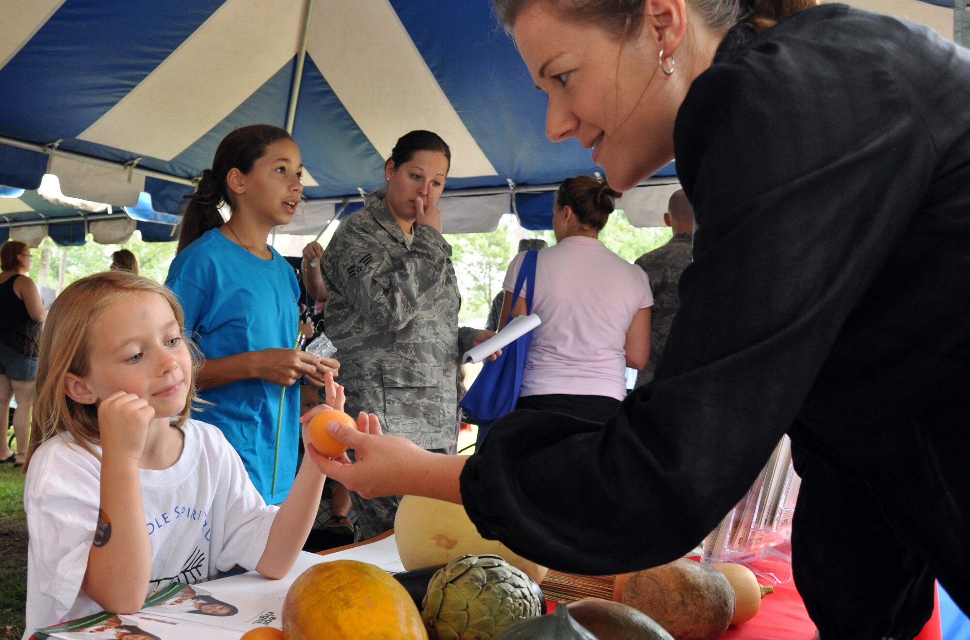 EGLIN AIR FORCE BASE, Fla. -- Sarah Shaffer, daughter of Tech. Sgt. Thomas Shaffer, 96th Security Forces Squadron, identifies fruits and vegetables with the help of Melissa Brannon, Eglin Health and Wellness Center nutrition program manager and dietician. While teaching points on healthy eating, the HAWC awarded the young girl with a tee-shirt for knowing the food displayed at their info booth during Eglin’s community picnic June 5. Sarah’s father is Tech. Sgt. Thomas Shaffer, 96th Security Forces Squadron. (U.S. Air Force photo/ Airman Anthony Jennings)