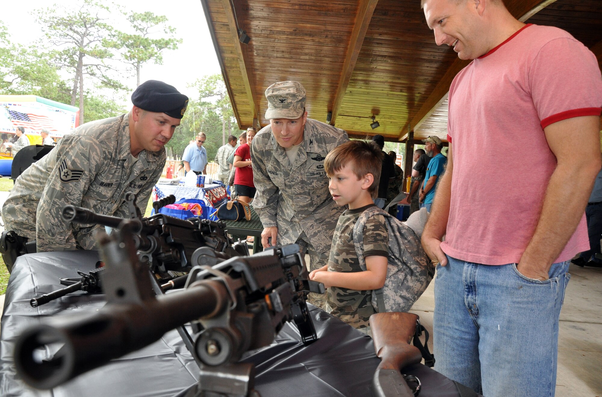 EGLIN AIR FORCE BASE, Fla. -- William Calhoun, six-year-old son of Tech. Sgt. Christopher Calhoun, 33rd Aircraft Maintenance Squadron, (far right), gets a lesson on the M-4 rifle from a 96th Security Forces Squadron member while Col. Alan Bridges, 96th Mission Support Group commander, listens in at the community picnic June 5. Staff Sgt. Tory Wagner (pictured) was on hand to demonstrate weapons to the crowd. (U.S. Air Force photo/ Airman Anthony Jennings)