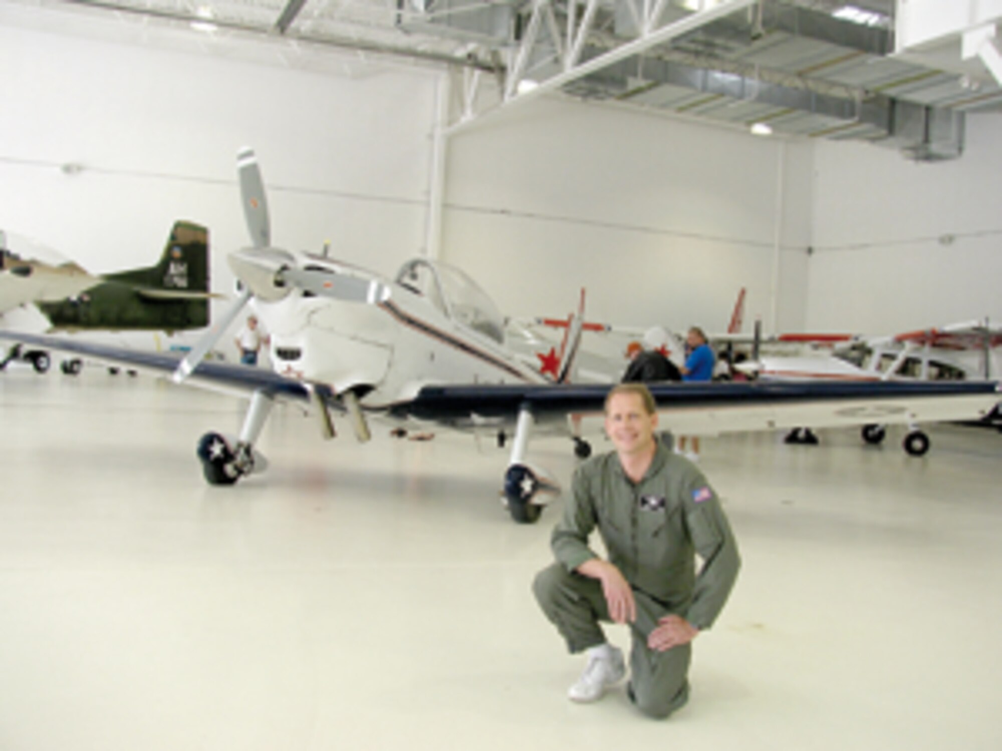 Dave Erickson, a technical program manager with the 517th Software Maintenance Squadron here, kneels next to his De Havilland Super Chipmunk during the Ogden Hinckley Airport Open House on June 4. Mr. Erickson will be performing war bird aerobatic maneuvers in this airplane during the Hill Air Force Base Open House and Air Show, June 6-7. (U.S. Air Force photo by Lee Anne Hensley)
