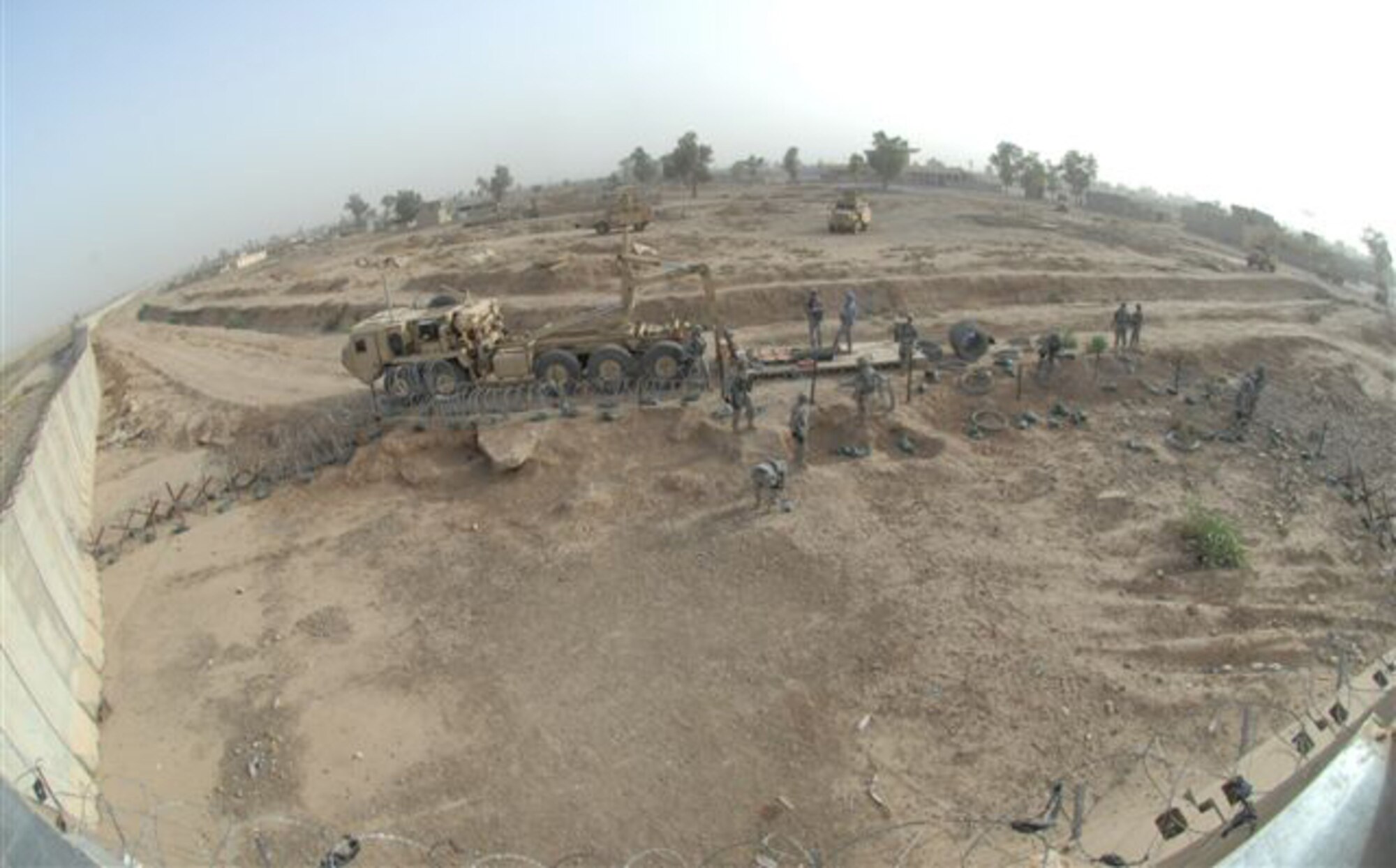 Tech. Sgt. Steven Durham and other Airmen in the 506th Expeditionary Security Forces Squadron build a concertina wire fence outside Kirkuk Regional Air Base, Iraq, May 30, 2009. The c-wire and other barriers placed around a security tower help mitigate threats against the installation. Sergeant Durham was recently chosen the 506th Air Expeditionary Group NCO of the month. (U.S. Air Force photo/Staff Sgt. Eunique Stevens)