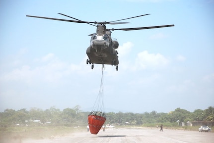 A CH-47 Chinook helicopter from Joint Task Force-Bravo at Soto Cano Air Base, Honduras, takes off with a Bambi bucket to fight a fire in National Park Jeannette Kawas near Tela, Honduras, June 3. The Chinook made 35 runs in all -- dropping more than 60,000 gallons of water to douse the flames in the national wildlife preserve that was inaccessible by ground. (U.S. Air Force photo/Tech. Sgt. Rebecca Danet)
