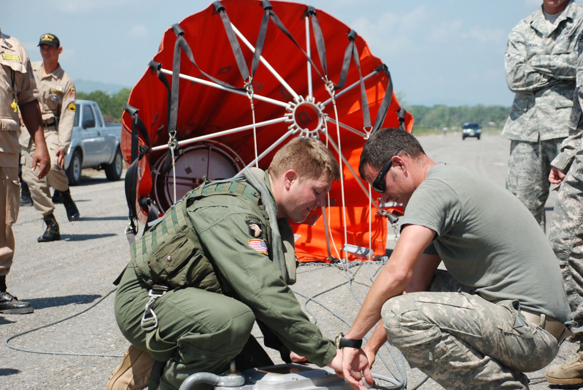U.S. Army Sgts. Sidney Scott (left) and Michael Marquis, Joint Task Force-Bravo, work to attach a Bambi Bucket to a CH-47 Chinook helicopter to fight a forest fire near Tela, Honduras, June 3.  In all, the flight crew made 35 runs -- dropping more than 60,000 gallons of water on the blaze in a national wildlife reserve.  (U.S. Air Force photo/Tech. Sgt. Rebecca Danét)