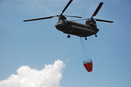 A CH-47 Chinook helicopter from Joint Task Force-Bravo at Soto Cano Air Base, Honduras, prepares to drop 2,000 gallons of water on a fire in National Park Jeannette Kawas near Tela, Honduras, June 3.  The Chinook made 35 runs in all -- dropping more than 60,000 gallons of water to douse the flames in the national wildlife preserve that was inaccessible by ground.  (U.S. Air Force photo/Tech. Sgt. Rebecca Danét) 