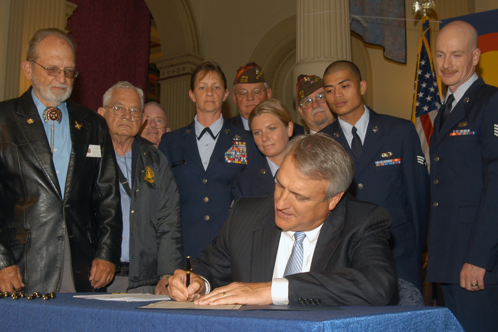 Soldiers and Airmen representing the Colorado National Guard and the Air Reserve Personnel Center, along with local veterans, watch as Gov. Bill Ritter signs a proclamation dedicating 2009 to NCOs serving in Colorado. The proclamation was signed June 2 at the state capitol in Denver. (U.S. Air Force photo/Tech. Sgt. Cheresa D. Theiral)