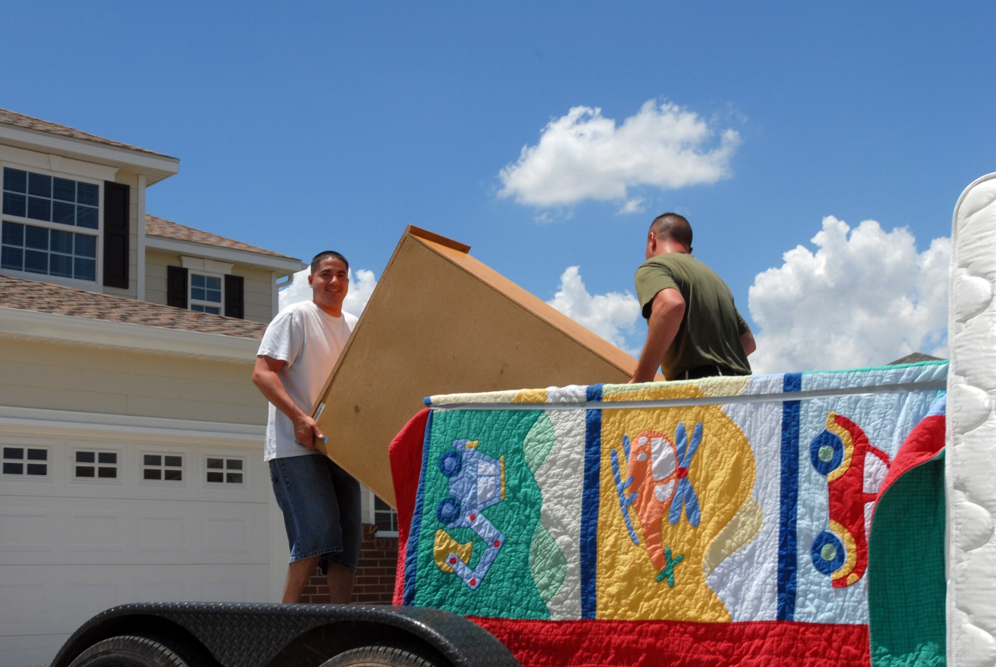 Marine Staff Sgt. George Vargas, 312th Training Squadron, is assisted by Marine Staff Sgt. Timothy Muckey-Quizado as he moves furniture into his new home in The Landings at Goodfellow off-base privatized housing. (U.S. Air Force photo by Airman Clayton Lenhardt)