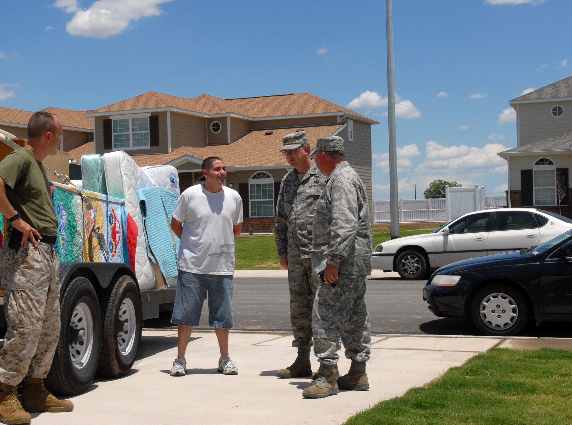 Colonel Richard Ayres, 17th Training Wing commander, accompanied by Colonel David Rearick, 17 TRW vice commander, speaks to Marine Staff Sgts. George Vargas and Timothy Muckey-Quizado at the new privatized housing. (U.S. Air Force photo by Airman Clayton Lenhardt)