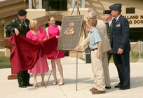 Team Lackland representatives and family members of  Army Lt. Col. Daniel Holland, an Army veterinarian killed in Iraq, unveil a plaque dedicated to the memory of Colonel Holland May 28. (U.S. Air Force photo/Robbin Cresswell) 