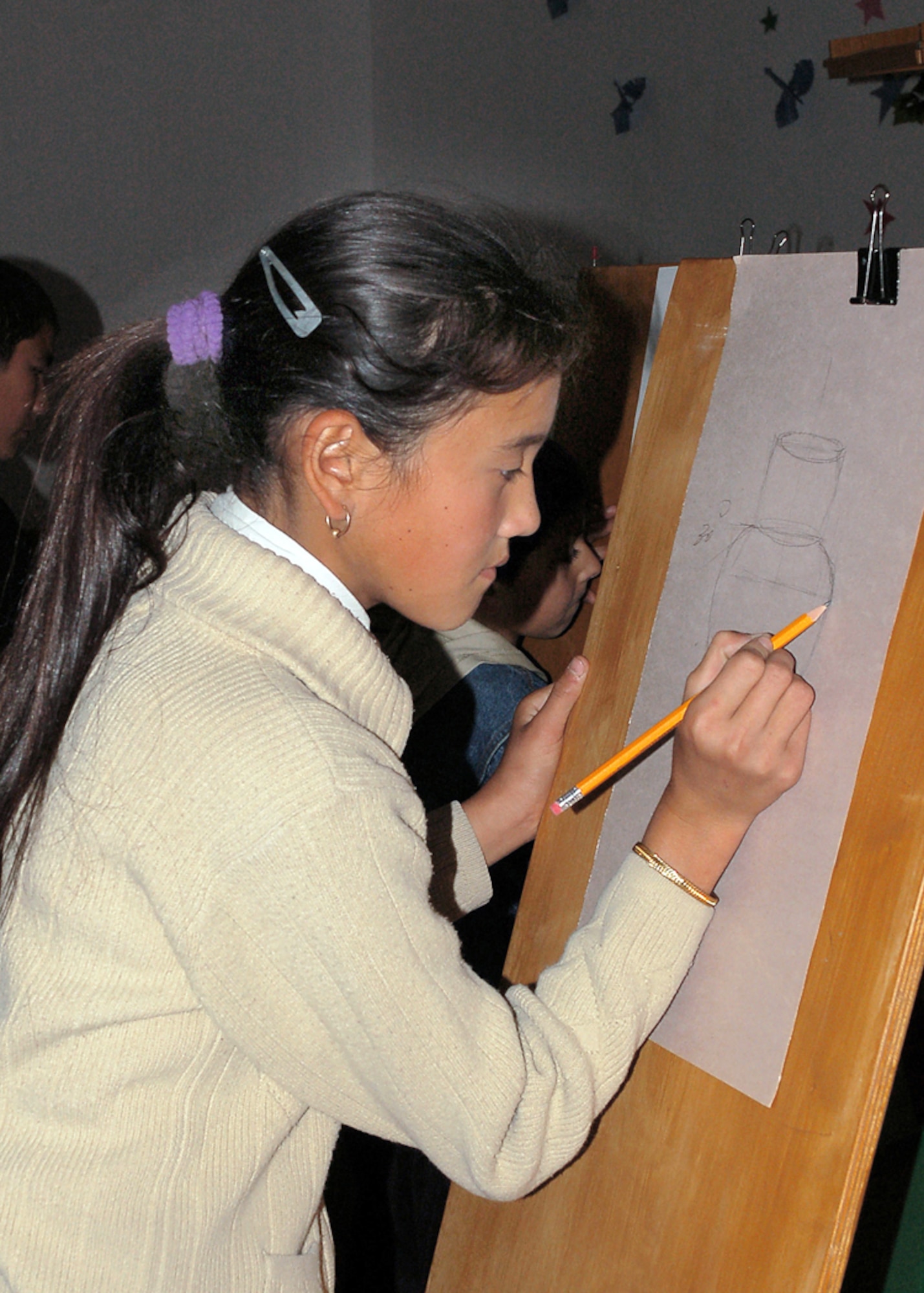 A student at Manas Village School draws a picture using an easel that was recently donated by the 376th Expeditionary Medical Group at Manas Air Base, Kyrgyzstan. The easels were built by students at Kingswood Regional High School in Kingswood, N.H. (U.S. Air Force photo/Tech. Sgt. Elizabeth Weinberg) 
