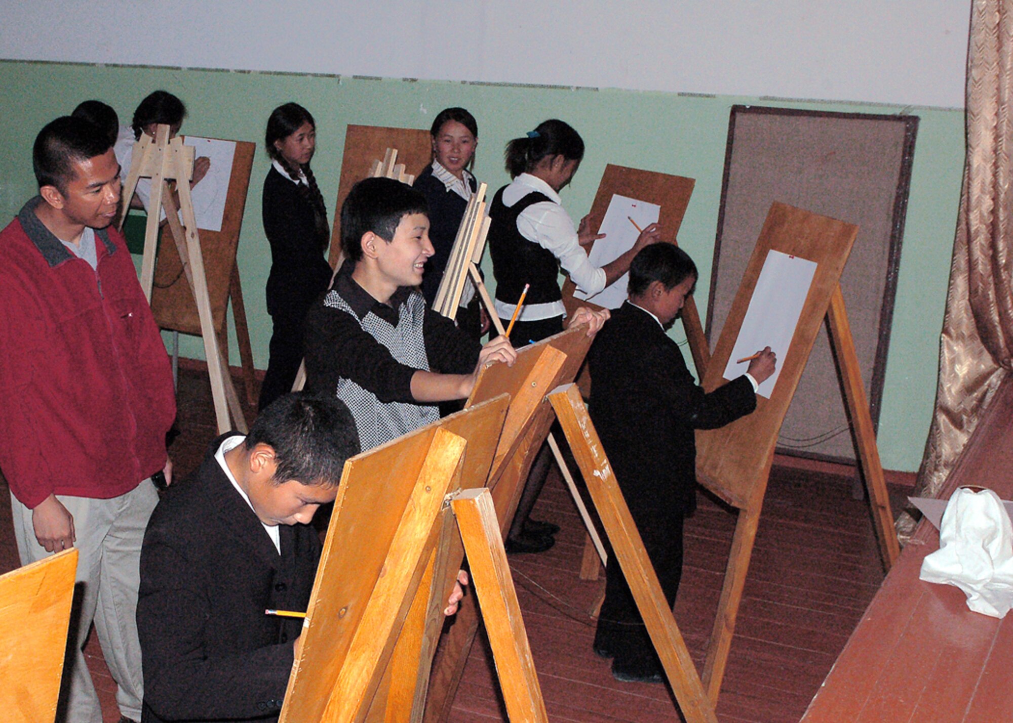 Students at Manas Village School in Kyrgyzstan draw pictures using easels donated by American friends and family members of the 376th Expeditionary Medical Group at Manas Air Base, Kyrgyzstan. (U.S. Air Force photo/Tech. Sgt. Elizabeth Weinberg)