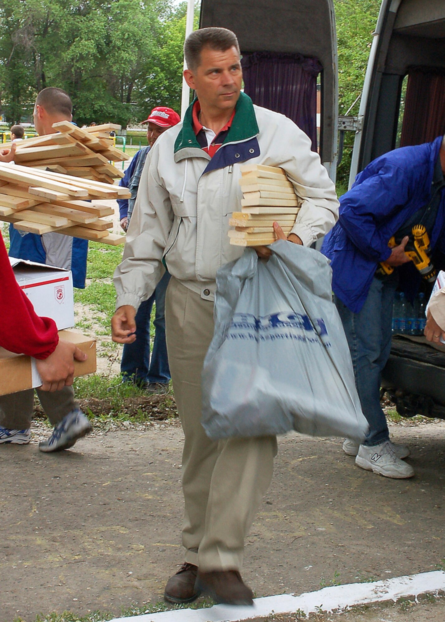Col. Gerard Caron carries art supplies to the Manas Village School in Kyrgyzstan. 376th Expeditionary Medical Group members from Manas Air Base, Kyrgyzstan, delivered handmade art easels and art supply donations to the school in May. Colonel Caron is 376th EMDG commander and is deployed from the Air Education and Training Command at Randolph Air Force Base, Texas. (U.S. Air Force photo/Tech. Sgt. Elizabeth Weinberg) 
