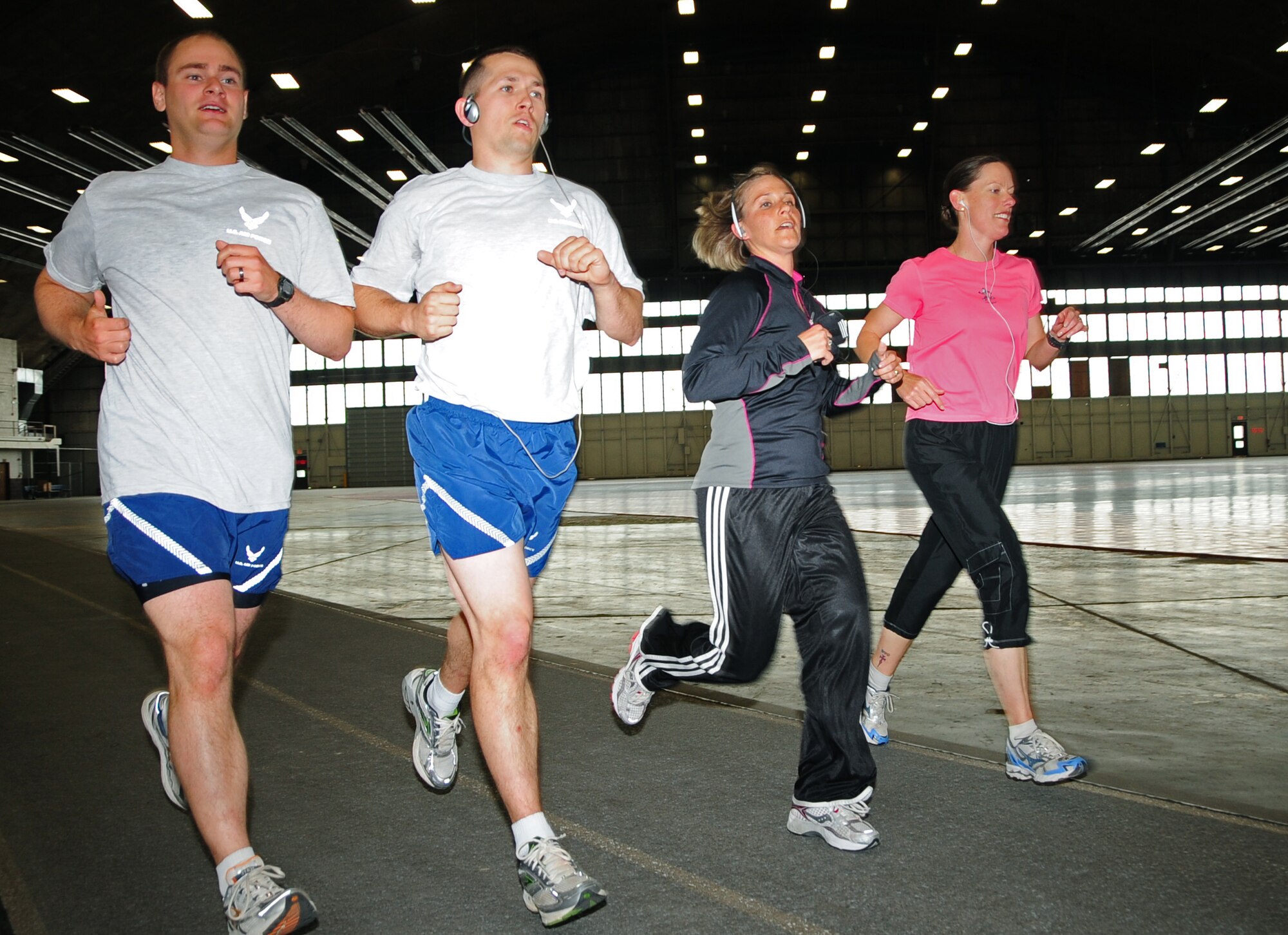 Airmen of the 28th Force Support Squadron,(left to right) Senior Airman Kirby McDonald, installation personnel readiness journeyman; 1st Lt. Adam Baker, sustainment flight commander;  Tech. Sgt. Ann Mitchell, NCO in charge of readiness; and Maj. Launa Bellucci, 28 FSS commander, run together at the PRIDE Hangar here, June 03.  These Airmen run together to prepare themselves as part of a seven-person-marathon team led by Major Bellucci. (U.S. Air Force photo/Senior Airman Anthony Sanchelli)