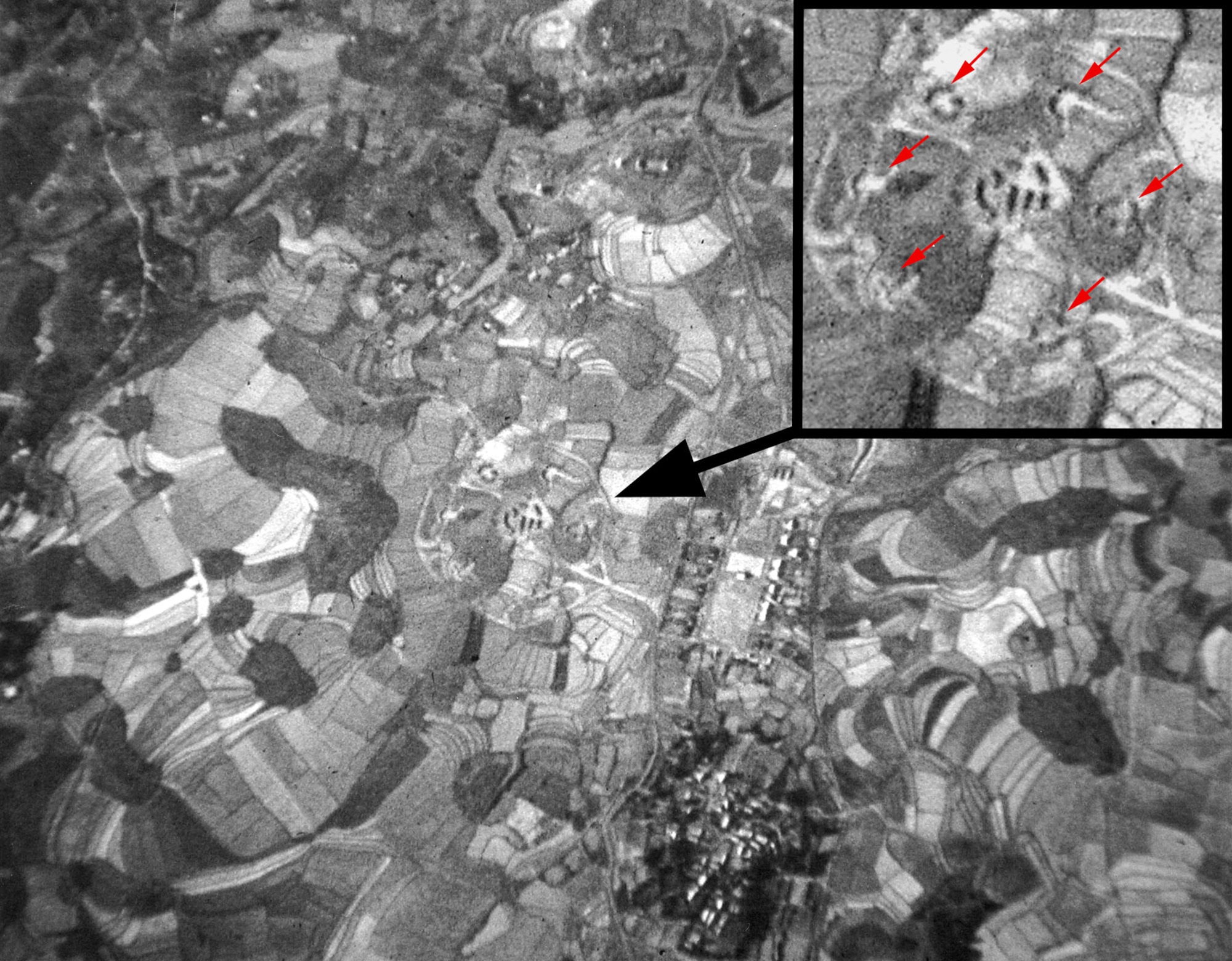 Taken over North Vietnam in January 1967, this photograph illustrates the difficulty of visually spotting a SAM site. Wild Weasels used specialized electronic equipment to find the SAM sites. Red arrows in closeup point to the six SA-2 launchers in revetments. (U.S. Air Force photo)