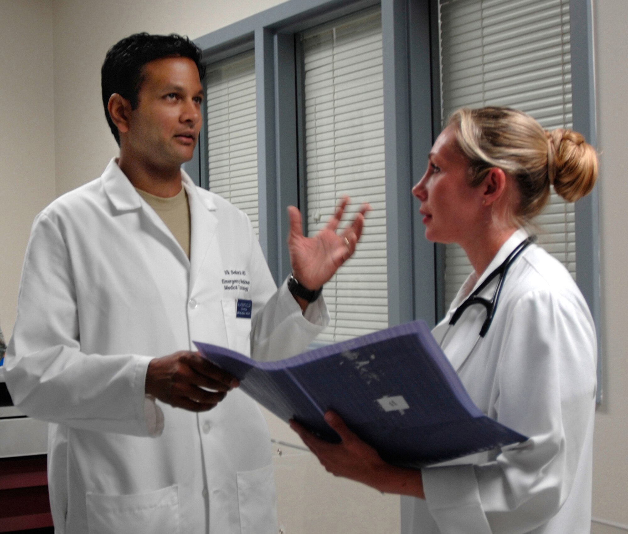 Emergency physicians Majs. (Drs.) Vikhyat Bebarta (left) and Annette Williams discuss patient care in the Wilford Hall Medical Center emergency department at Lackland Air Force Base, Texas. Dr. Bebarta received the Best Basic Science Research Award by the Society of Academic Emergency Medicine for his research on evaluating treatments for cyanide poisoning.  (U.S. Air Force photo/Master Sgt. Kimberly A. Yearyean-Siers) 