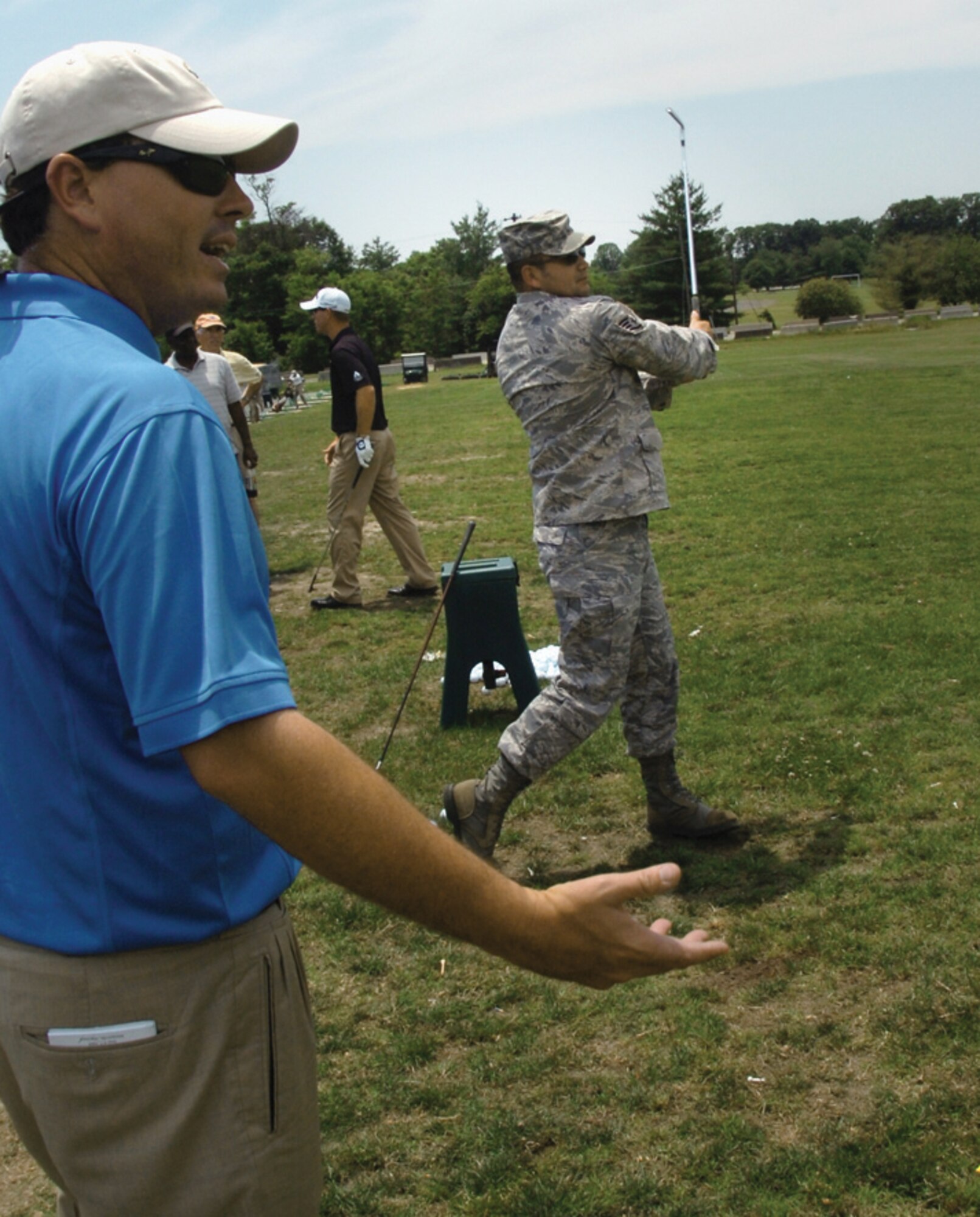 Kris Cox, Professional Golf Association pro, commends Staff Sgt. Oscar Castro, 844th Communication Group training manager, on his swing during the free golf clinic at The Courses at Andrews Tuesday. (U.S. Air Force photo/ Bobby Jones)