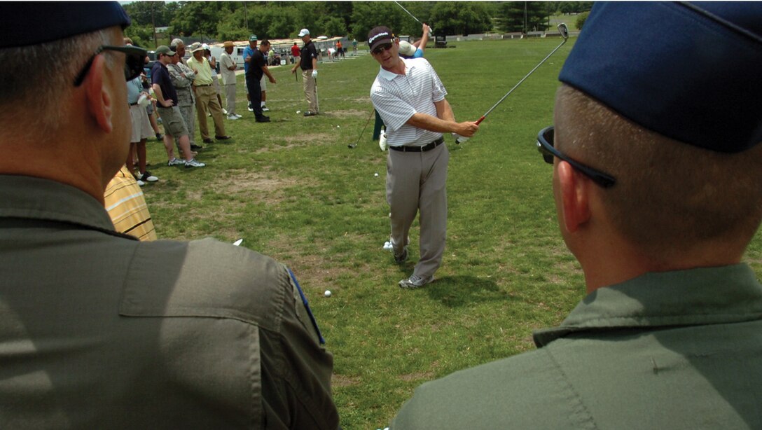 Jason Schultz, a professional golfer scheduled to play in the Nationwide Tour, demonstrates his follow through technique to Andrews Airmen during a free golf clinic at The Courses at Andrews Tuesday. Several Active Duty members, military retirees and civilians got tips on the basic fundamentals from Mr. Schultz, Kris Cox and Josh Broadaway during the hour-long clinic. (U.S. Air Force photo/ Bobby Jones)