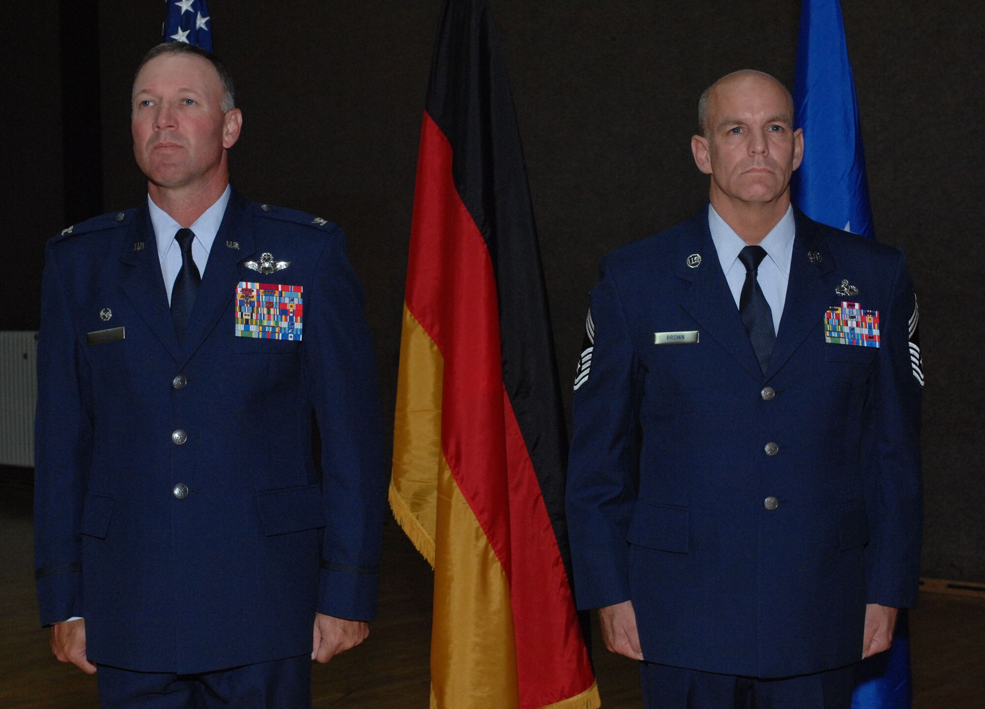 SPANGDAHLEM AIR BASE, GERMANY – Col. Lee T. Wight 52nd Fighter Wing commander, and Chief Master Sgt. William J. Brown, 52nd Component Maintenance Squadron propulsion systems manager, stand at attention prior to a presentation of the Bronze Star during the 52nd Maintenance Group Unit Compliance Inspection call June 1, 2009 at the base fitness center. Chief Brown received the medal for contributing to the execution of 998 aircraft sorties, resulting in 10,541 hours of critical armed overwatch and medical evacuation. He also initiated and led a tiger team to re-organize Camp Samek, enhancing the group’s operational efficiency and quality of life. Chief Brown secured essential workspace, housing accommodations and other base support for a vital Red Horse team enabling the completion of high-priority construction projects for a Secretary-of-Defense initiative to deploy 3,700 additional Marines. (U.S. Air Force photo by Master Sgt. Bill Gomez)