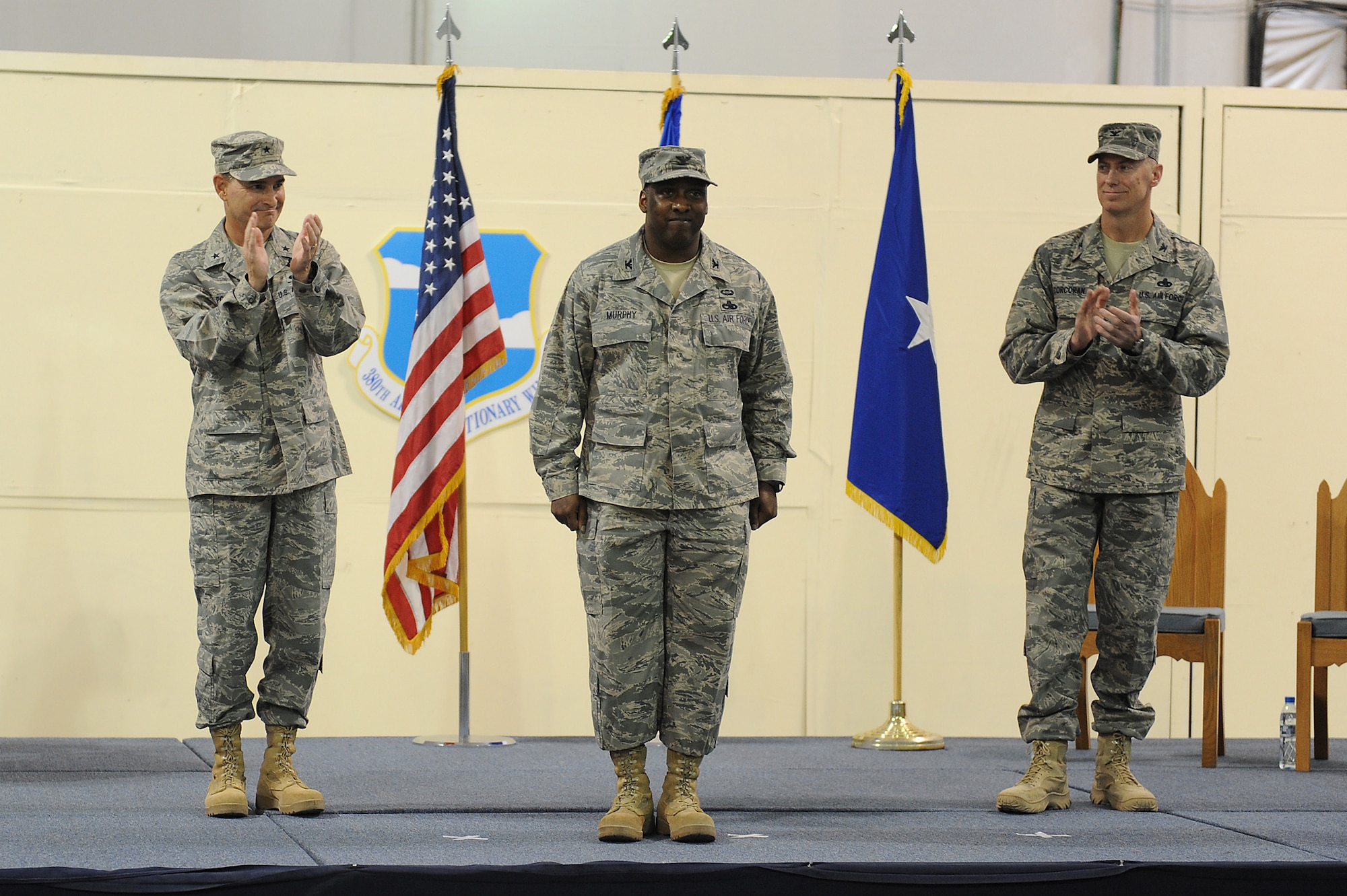 SOUTHWEST ASIA - Brig. Gen. H.D. Polumbo Jr., 380th Air Expeditionary Wing, commander, and Col. Raymond Corcoran, former 380th Expeditionary Maintenance Group commander applaud Col. Ricky Murphy after he took command of the 380th EMXG during a ceremony, June 5 at an undisclosed location in Southwest Asia. Colonel Murphy comes from the Pentagon as the Logistics Panel Chairman joining the 380th Air Expeditionary Wing to lead the 380th EMXG. (U.S. Air Force photo by Senior Airman Brian J. Ellis) (Released)