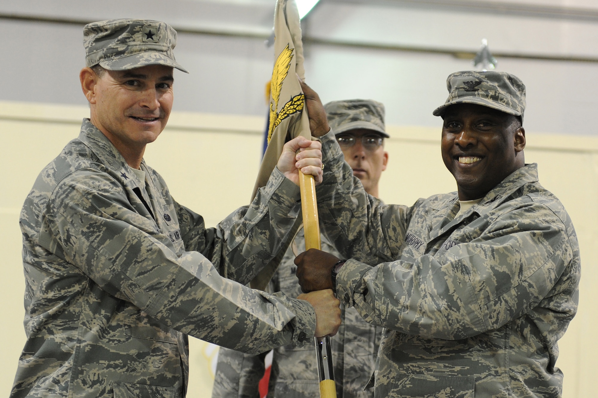 SOUTHWEST ASIA - Brig. Gen. H.D. Polumbo Jr., 380th Air Expeditionary Wing, commander, passes the flag of the 380th Expeditionary Maintenance Group to Col. Ricky Murphy as he takes command, June 5 at an undisclosed location in Southwest Asia. Colonel Murphy comes from the Pentagon as the Logistics Panel Chairman joining the 380th Air Expeditionary Wing to lead the 380th EMXG. (U.S. Air Force photo by Senior Airman Brian J. Ellis) (Released)