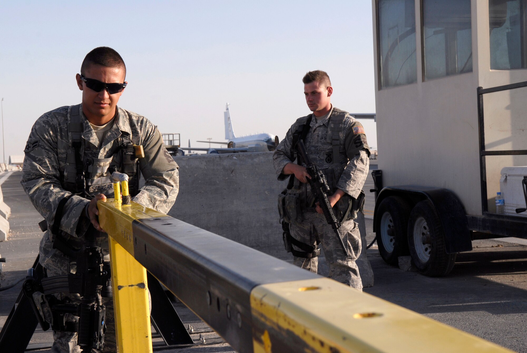 Airman 1st Class Christopher Salazar, a 379th Expeditionary Security Forces Squadron (ESFS) entry controller, opens his gate to the flightline at his entry control point while Senior Airman Chad Byall, another 379th ESFS entry controller, stands as an over-watch, Jun 4, 2009 at an undisclosed location in Southwest Asia.  Both Airmen ensure that personnel who are attempting to gain access to the flightline have authorization to do so.  Airman Salazar hails from Colorado Springs, Colo. and is deployed from Royal Air Force Mildenhall, England.  Airman Byall hails from Hattiesburg, Miss. and is deployed from Keesler Air Force Base, Miss.  Both are deployed in support of Operations Iraqi and Enduring Freedom and Combined Joint Task Force - Horn of Africa.  (U.S. Air Force photo/Senior Airman Andrew Satran/released)