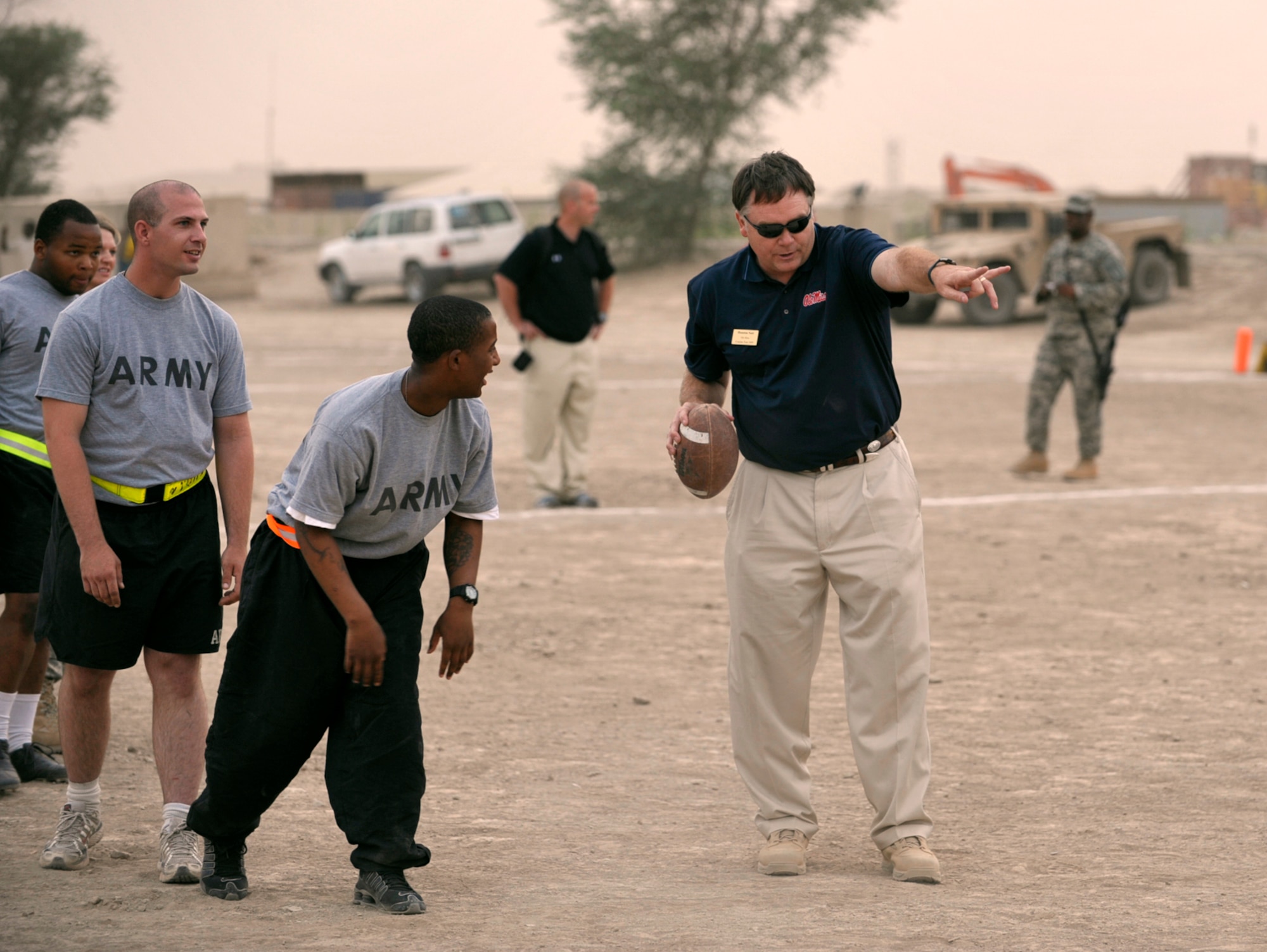 Houston Nutt, head football coach at Ole Miss, directs a soldier during a drill session with NCAA football coaches at Camp Victory, Iraq. Nutt is one of seven coaches participating in Coaches Tour 2009, a morale-boosting mission organized by Morale Entertainment, LLC., in association with Armed Forces Entertainment. Capt. Eric Junkins, a KC-135 pilot assigned to the 931st Air Refueling Group, was part of the aircrew that flew coaches from McConnell Air Force Base, Kan., to troops overseas. (U.S. Air Force photo/Tech. Sgt. Jason Schaap)