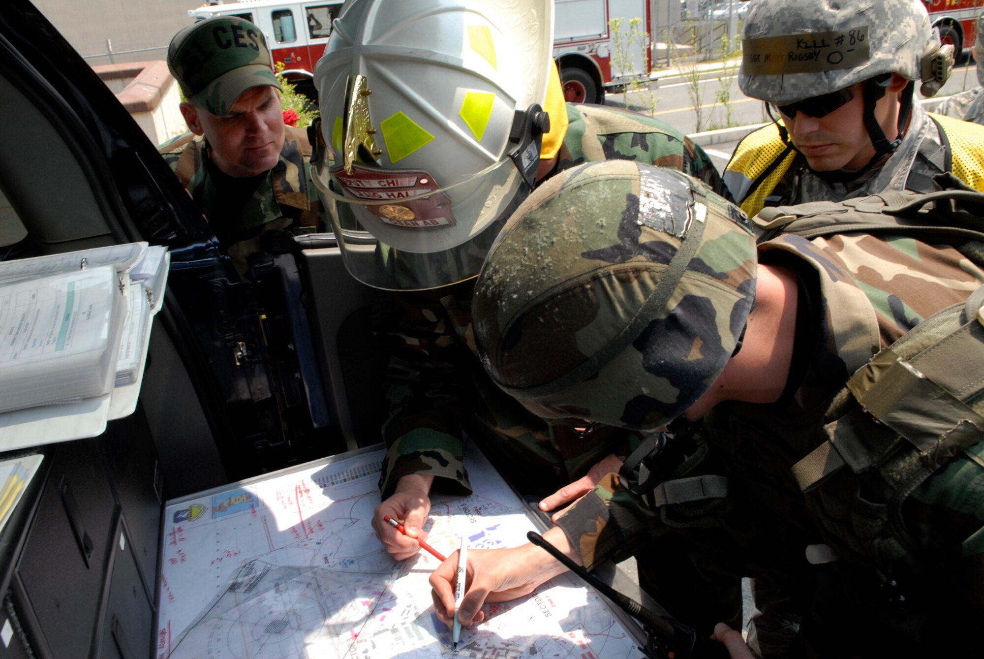 The on-scene commander from the 51st Civile Engineer Squadron Fire Department examines a map of Osan Air Base at the entry control point to ensure a cordon is established during the exercise May 28. EME’s are held quarterly here to test Osan’s preparedness for force protection issues and acts of terrorism. (U.S. Air Force photo/Senior Airman Stephenie Wade)