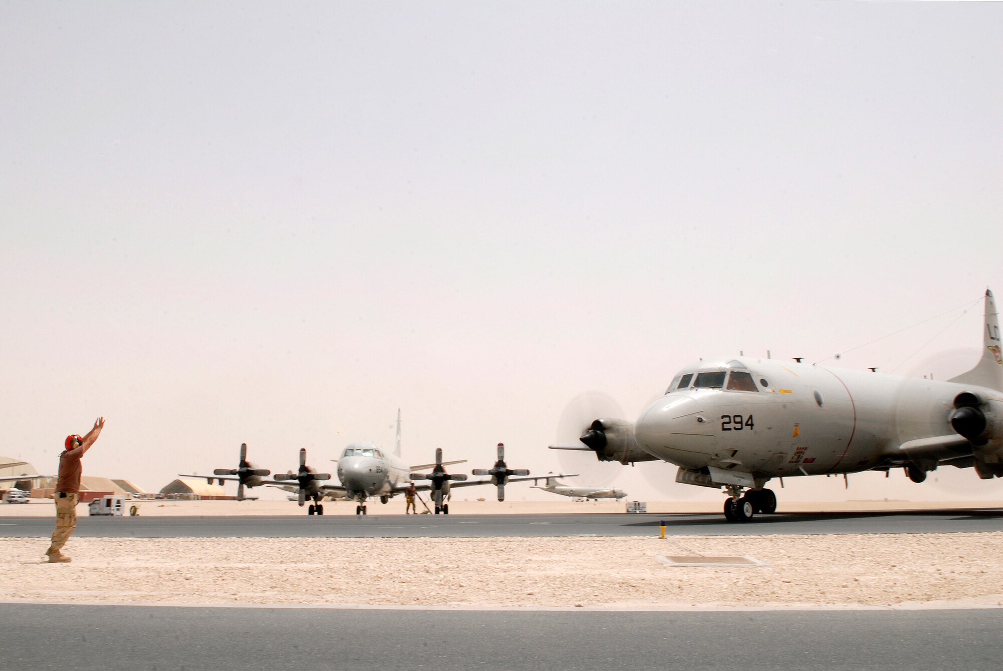 Naval Petty Officer 3rd Class Herson Sanchez, Patrol Squadron EIGHT aviation ordnance technician, marshals a P-3C Orion to its parking spot after another mission, Jun 3, 2009, at an undisclosed location in Southwest Asia.  The P-3C provides an over-watch of U.S. and Coalition Forces, gathering intelligence to assist them on the ground and on the sea.  Petty Officer Sanchez hails from Lares, Puerto Rico and is deployed from Patrol Squadron 10, Jacksonville, Fla. in support of Operations Iraqi and Enduring Freedom and Combined Joint Task Force - Horn of Africa.  (U.S. Air Force photo/Senior Airman Andrew Satran/released)