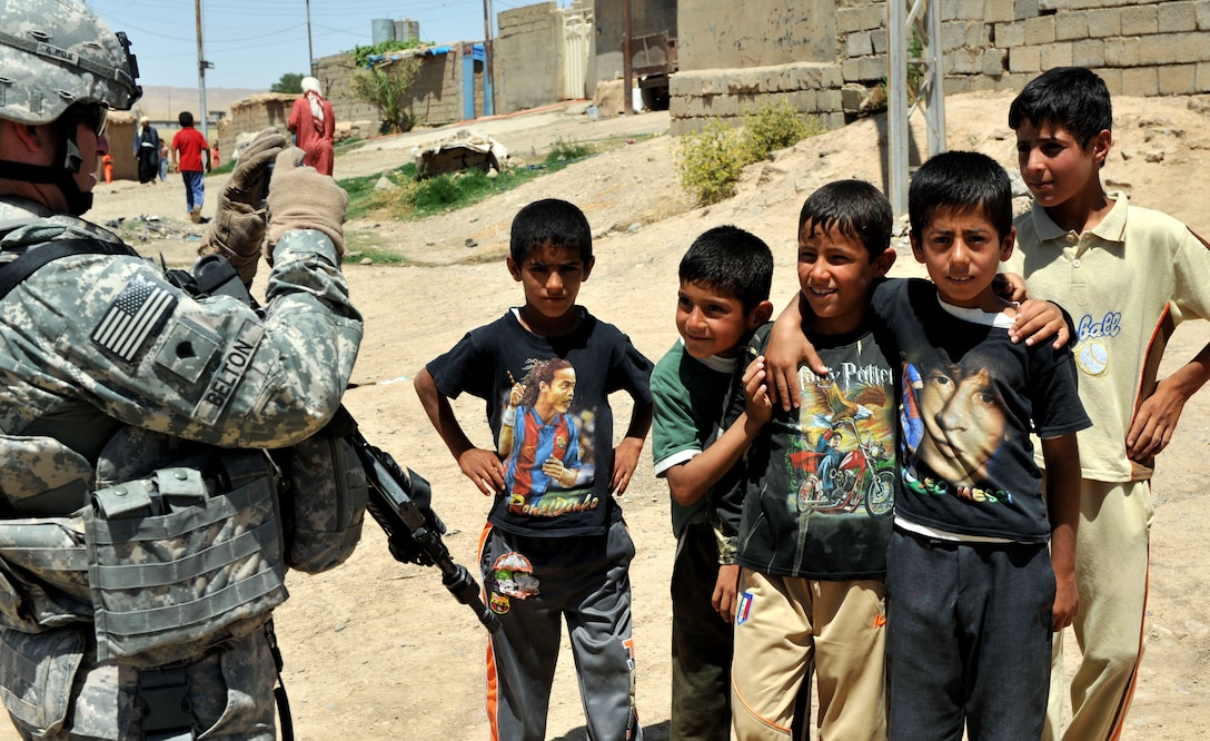 U.S. Army Spc. Joe Belton takes pictures of Iraqi boys in the village of Ka bashe in Kirkuk, Iraq, May 31, 2009. Belton is assigned to the 1st Cavalry Division's Company E, 1st Battalion, 8th Cavalry Regiment, 2nd Heavy Brigade Combat Team.