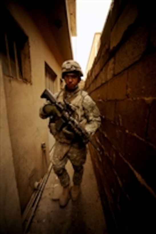 U.S. Army Staff Sgt. Henry Cuevas, with Charlie Company, 1st Battalion, 5th Infantry Regiment, 1st Stryker Brigade Combat Team, 25th Infantry Division, walks through an alley during a patrol in the Hay Mulameen neighborhood in Diyala province, Iraq, on May 31, 2009.  