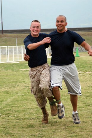 Members of the Air Fuel Operations team laugh as they struggled to race down the field during the three-legged race during the sports day at Penny Lake here June 5. The field meet had been in the works for about three months to give::r::::n::Marines of Marine Wing Support Squadron 171 a well-deserved day off.