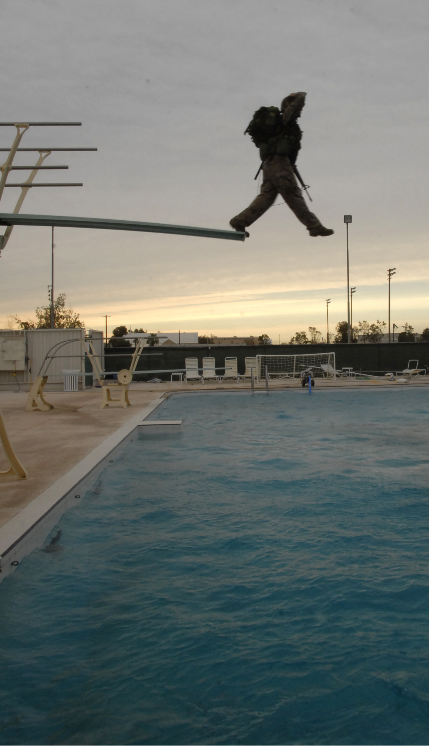 In full combat gear, Lance Cpl. Brittney Garland, a military policeman from the Marine Corps Air Station in Yuma, Ariz., steps off a diving board during water survival training at the Naval Air Facility in El Centro, Calif., June 5, 2009. Throughout June 1-5, 2009, Yuma Headquarters and Headquarters Squadron Marines tested for various qualification levels of combat water survival.