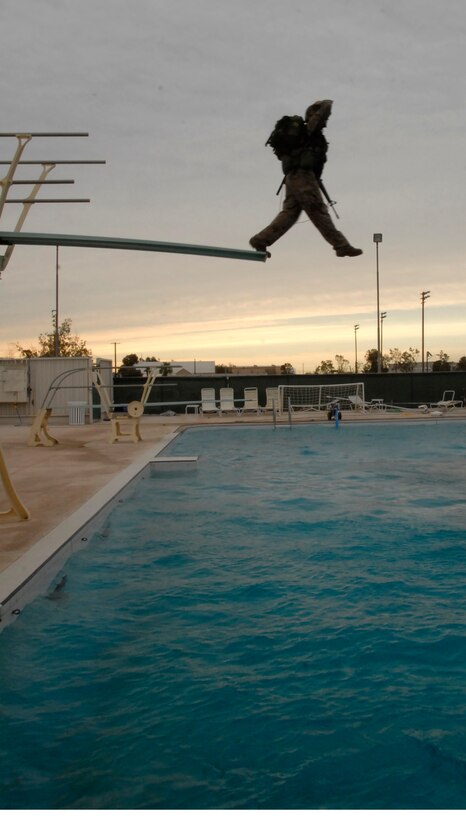 In full combat gear, Lance Cpl. Brittney Garland, a military policeman from the Marine Corps Air Station in Yuma, Ariz., steps off a diving board during water survival training at the Naval Air Facility in El Centro, Calif., June 5, 2009. Throughout June 1-5, 2009, Yuma Headquarters and Headquarters Squadron Marines tested for various qualification levels of combat water survival.
