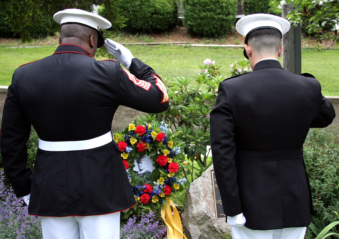 Sgt. Maj. Fenton Reese and Capt. Robert Germino salute a wreath-laden photo of Sgt. Maj. Daniel "Dan" J. Daly at his memorial in Glen Cove June 6. Daly, a native of Glen Cove, was a two-time Medal of Honor recipient and retired out of the Marine Corps Feb. 6, 1929.