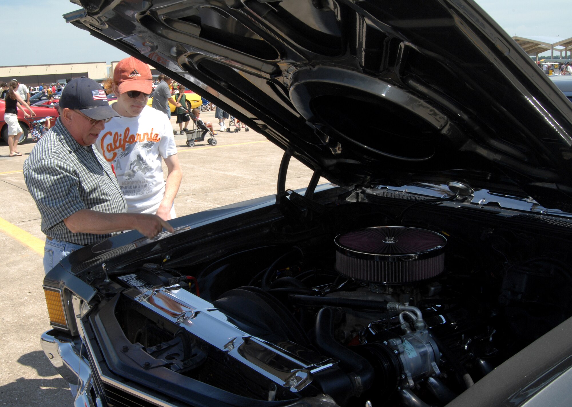 WHITEMAN AIR FORCE BASE, Mo. - Spectators admire a Chevy 1966 Supersport enigne June 6 at the Wings Over Whiteman Airshow. In addition to aircraft static displays and flyovers, the airshow also featured several classic cars as well as concerts featuring the Air Force Band of Mid-America and Lee Greenwood. (U.S. Air Force photo/Master Sgt. Stan Coleman)