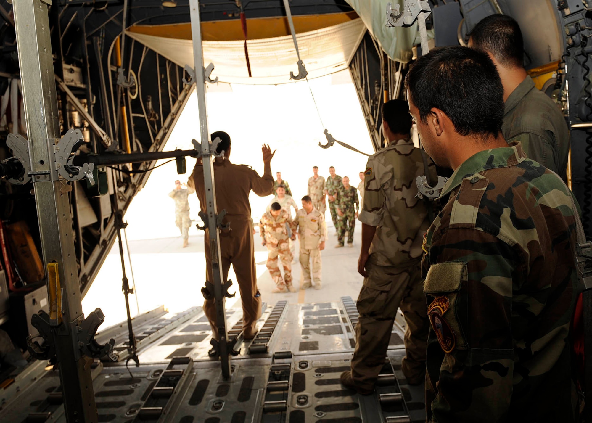 An Iraqi soldier watches as Iraqi Lieutenant Amar K. Gaad, nurse and flight medic instructor, marshals the litter into the C-130 Hercules during aero-medical evacuation transport training at New Al-Muthana Air Base, Iraq June 2, 2009.  The four week course, once taught by U.S. instructors, is now instructed by Iraqis. After the training the flight medics will be able to configure C-130 Hercules aircraft for aero-medical evacuation.  (U.S. Air Force photo by Senior Airman Jacqueline Romero)