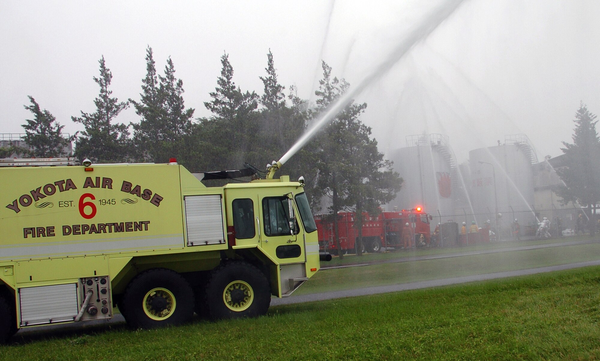 YOKOTA AIR BASE, Japan -- A P-23 Airport Rescue Fire Firefighting truck crew from the Yokota Air Base Fire Department takes part in a joint exercise with the Tokyo Fire Department June 5 on the northeast perimeter of the base. Two crews from Yokota helped put out a simulated fire at the Ishikawajima-Harima Heavy Industries Co., Ltd. factory in Mizuho during the exercise to demonstrate assistance provided by a mutual support agreement between the base and the Tokyo Fire Department. (U.S. Air Force photo/Master Sgt. Matt Summers) 